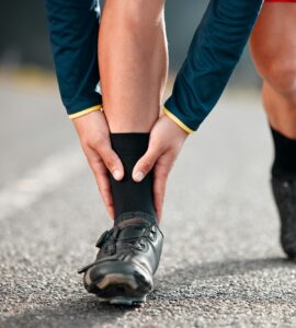 Run injury, feet and sport runner athlete on a outdoor road feeling ankle and sports pain. Leg musc