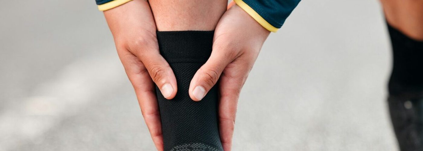 Run injury, feet and sport runner athlete on a outdoor road feeling ankle and sports pain. Leg musc